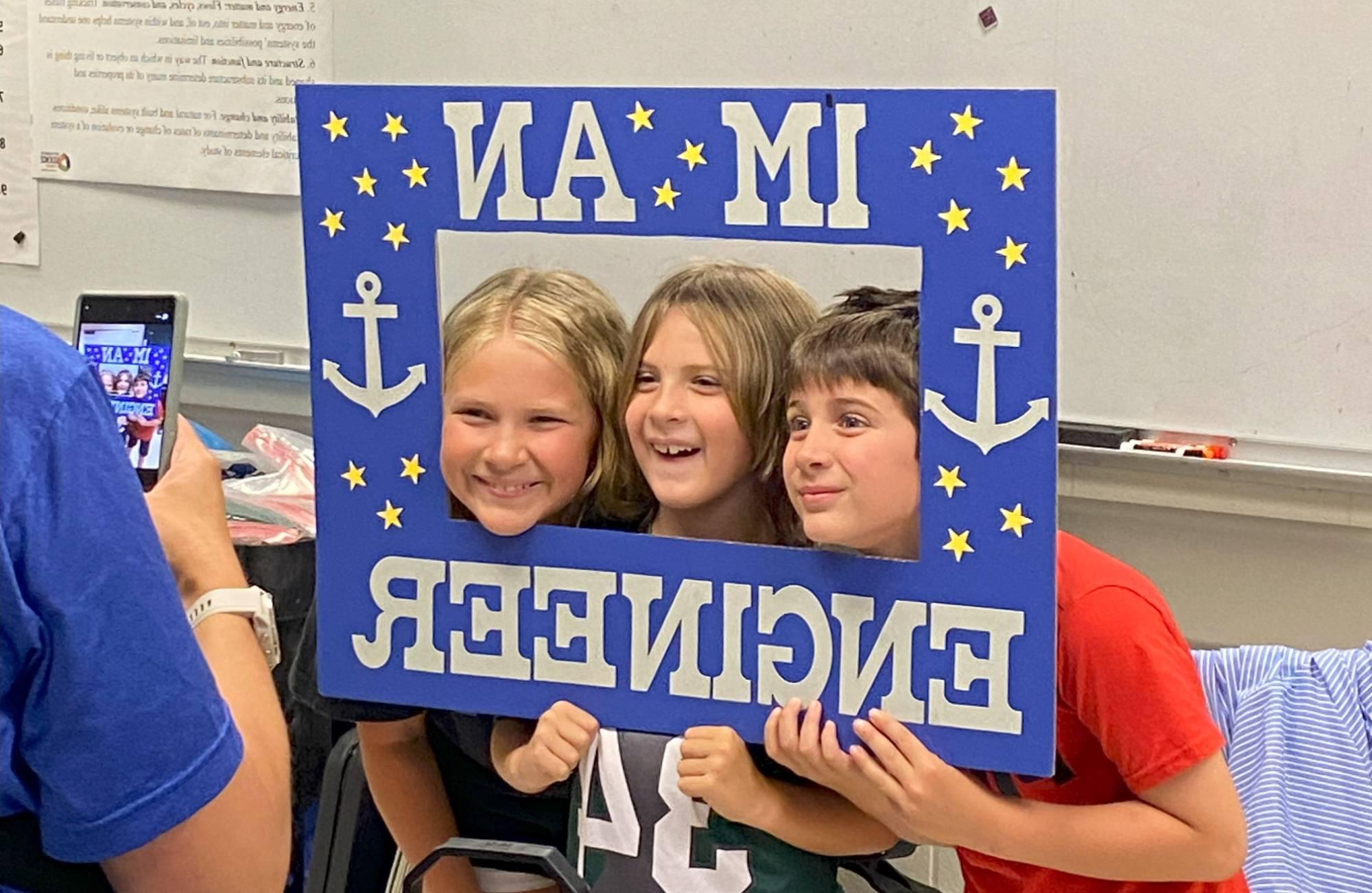 Children posing with engineering sign